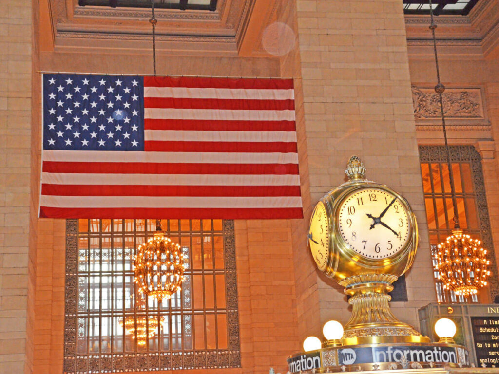 Uhr und USA Flagge im Bahnhof