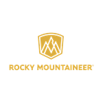 Goldfarbenes RockyMountaineer-Logo mit rundem Emblem und Schriftzug vor dunklem Hintergrund, passend zu Zugreisen in Kanada.