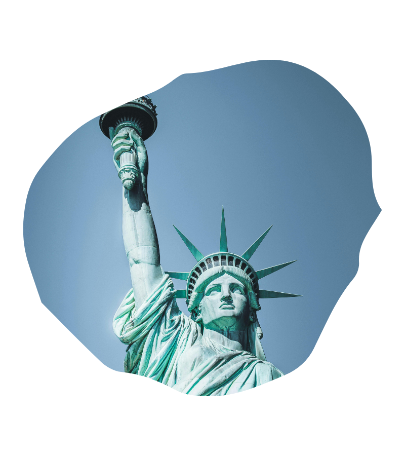 Die Statue of Liberty mit grünem Kupfer-Patina vor blauem Himmel steht als starker USA-Moment im Fokus.