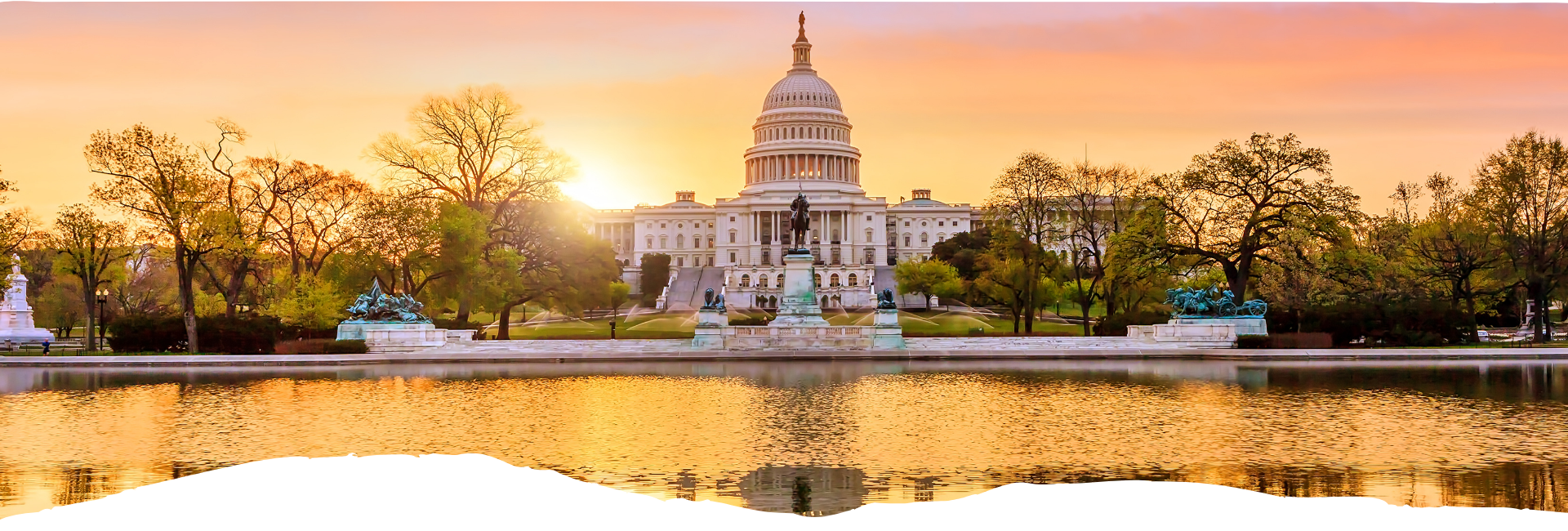 Goldenes Licht am Sonnenaufgang vor dem US Capitol mit ruhiger Spiegelung im Wasser, flankiert von gepflegten Bäumen und Parkanlagen.