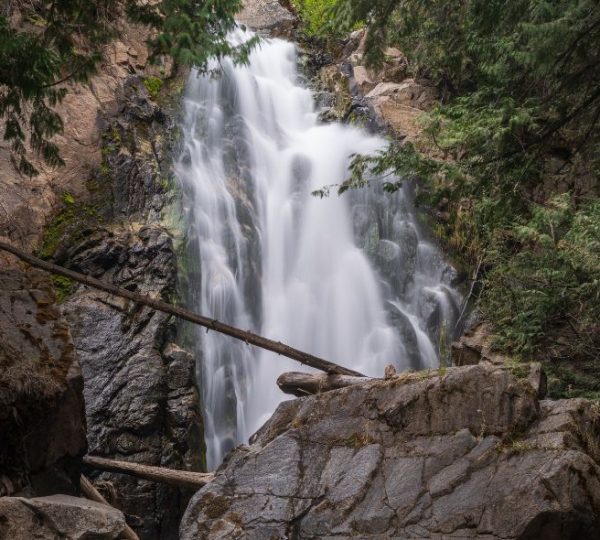 Ein breiter Wasserfall stürzt zwischen moosigen Felsen durch den Nadelwald nahe Winthrop im Bundesstaat Washington.