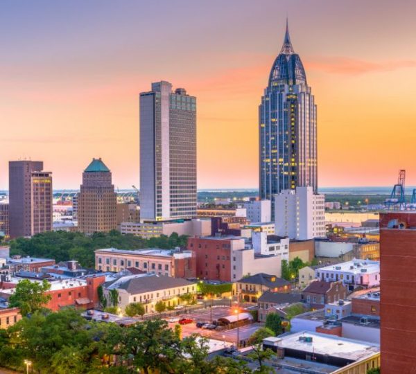 Die Skyline von Mobile in Alabama zeigt markante Hochhäuser im warmen Abendlicht während einer Südstaaten-Rundreise.