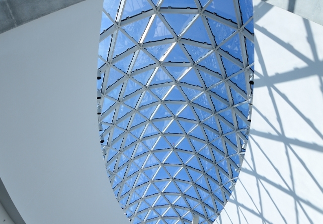 Unter dem blau verglasten Dach des Salvador Dali Museum zeichnen weiße Stahlträger ein geometrisches Muster und werfen klare Schatten.