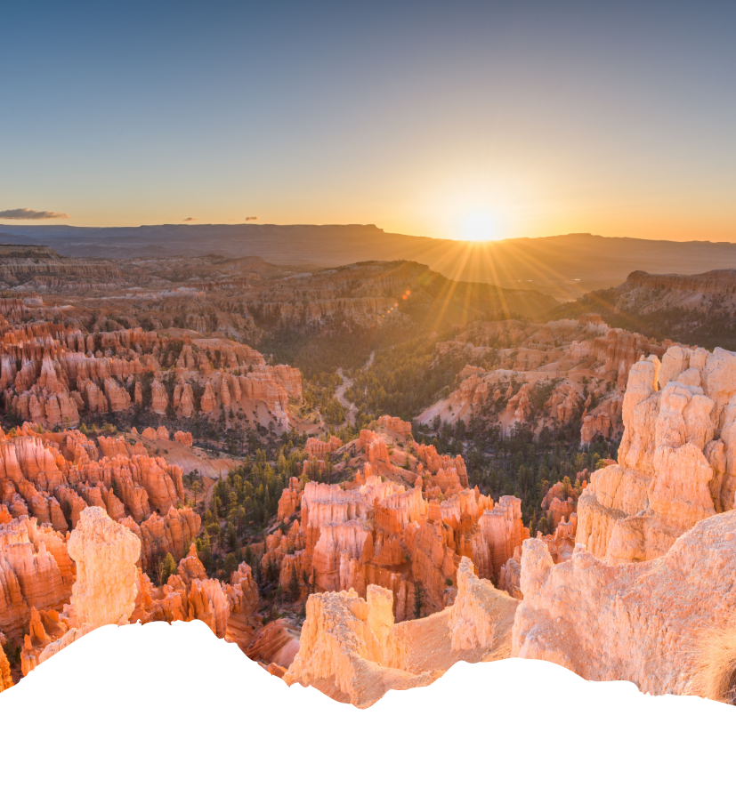 Beim Sonnenaufgang leuchten die roten Felsnadeln von Bryce Canyon National Park in warmem Licht, während die Sonne über dem Horizont Strahlen sendet.