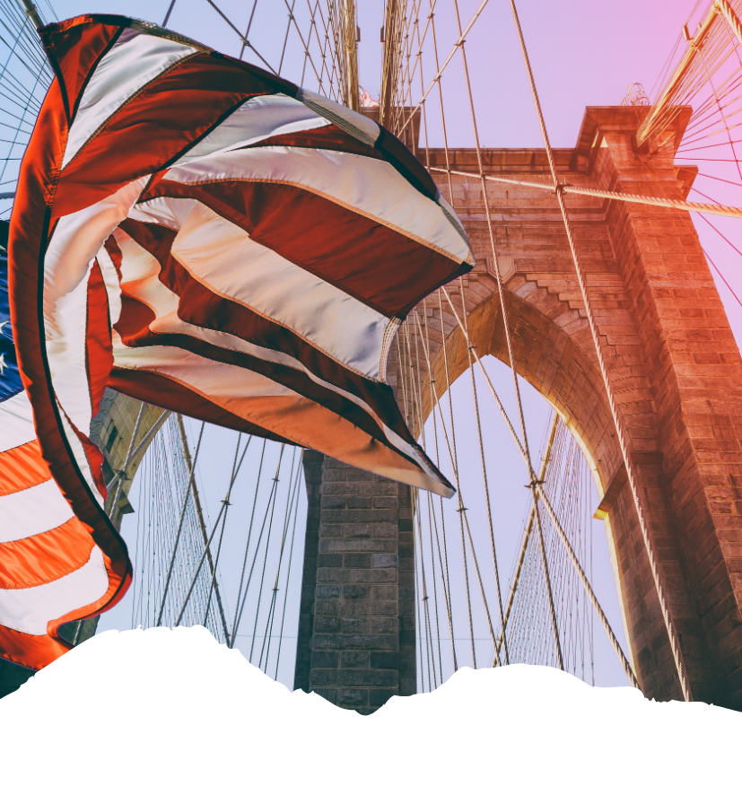 Im Sonnenschein weht eine US-Flagge vor der Brooklyn Bridge in New York und setzt einen markanten USA-Reiseakzent.