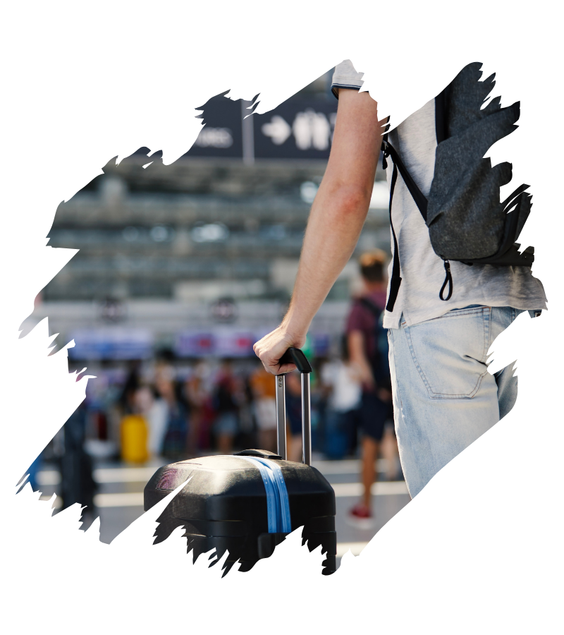 Ein Reisender mit Rucksack und Rollkoffer wartet im Flughafen auf den Umstieg, während die UK-ETA-Pflicht für die USA-Reise gilt.