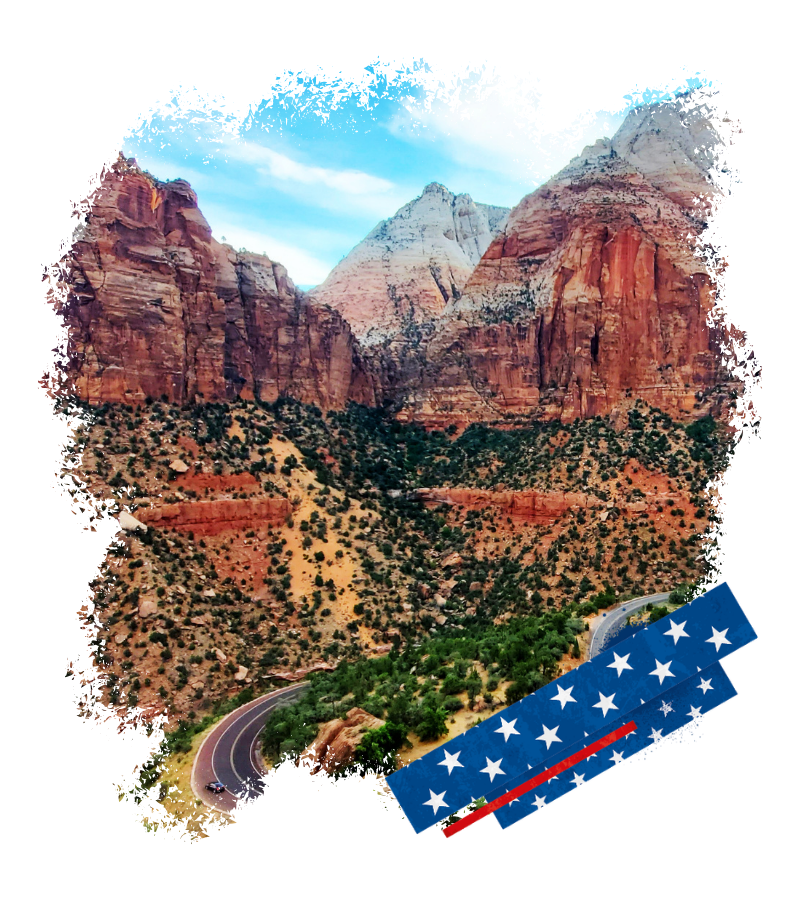 Im Zion Nationalpark windet sich eine Straße durch rotbraune Canyons unter hellen Felsgipfeln und blauem Himmel.