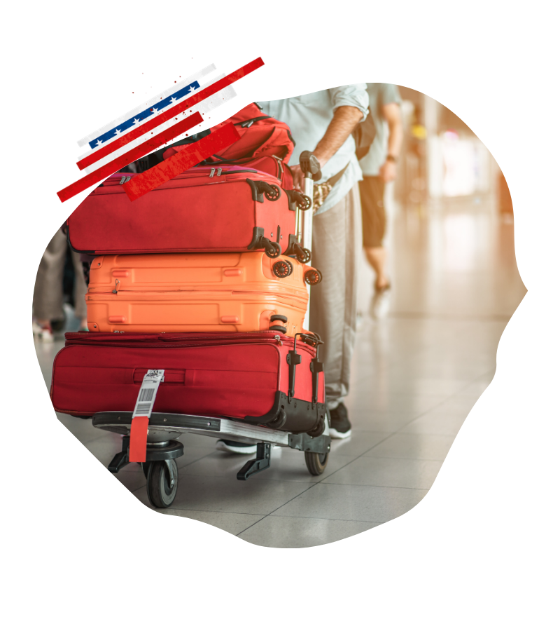 Am Flughafen schiebt eine Reisende einen Gepäckwagen mit roten und orangefarbenen Koffern im Terminal zum Online-Check-in für USA-Flüge.