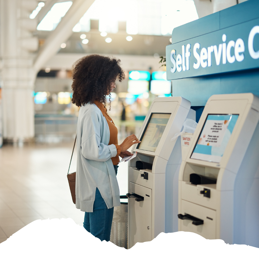 Eine Reisende nutzt am Flughafen einen Self-Service-Automaten und tippt den Online-Check-in für ihren USA-Flug ein.