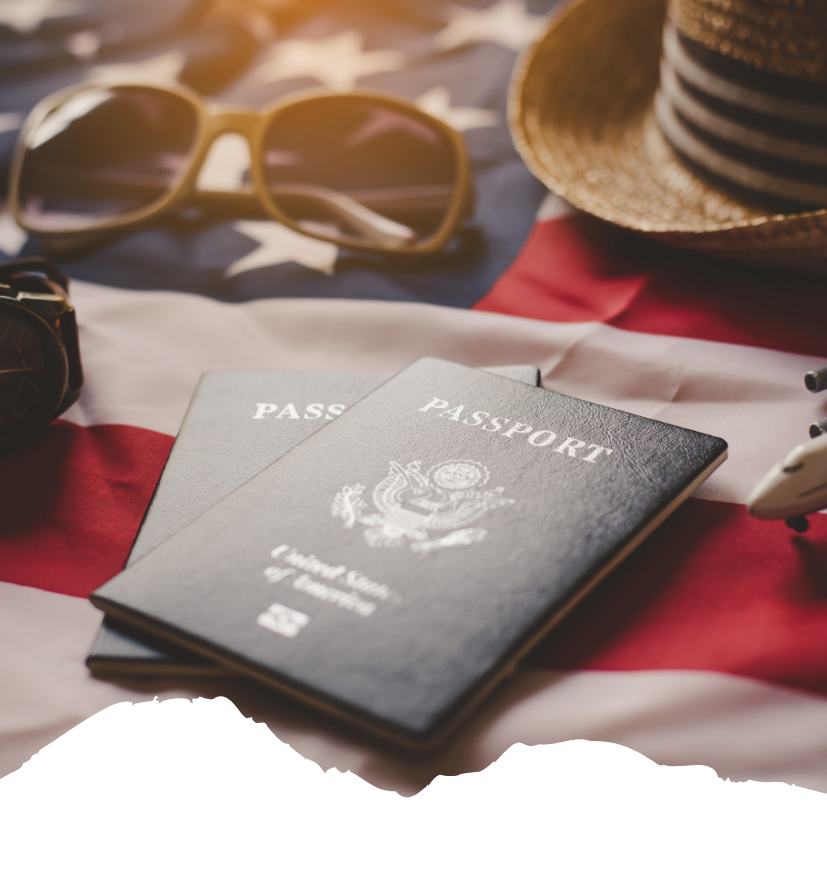 Zwei US-Pässe liegen auf einer amerikanischen Flagge, daneben Sonnenbrille und Strohhut als Reiseutensilien für die USA-Einreise.