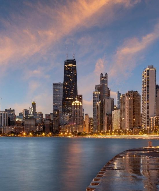 Chicago Skyline am Ufer des Michigansees im Abendlicht mit hohen Wolkenkratzern und ruhigem Wasser.