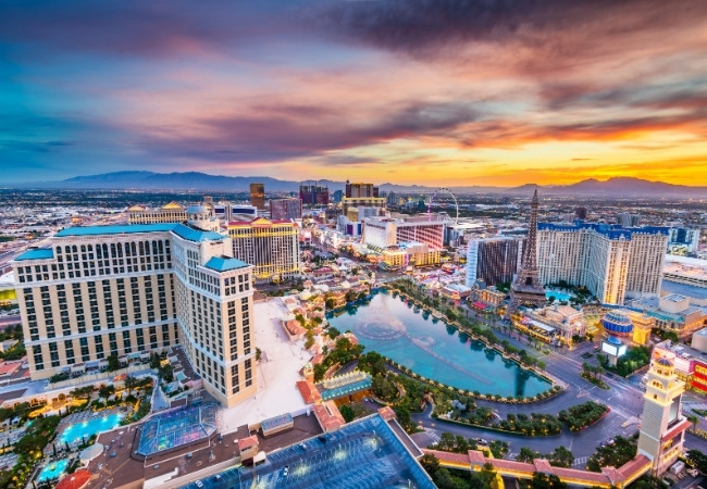 Der Las Vegas Strip leuchtet im Sonnenuntergang, mit dem Bellagio-See und dem Eiffelturm von Paris Las Vegas im Blick.