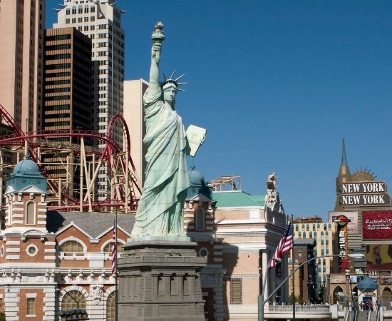 Die Freiheitsstatue und der New York-New York-Komplex prägen die Szene am Las Vegas Strip unter klarem Himmel.
