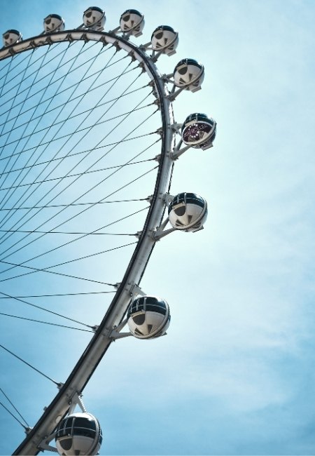 Der High Roller in Las Vegas zeigt mehrere silberne Gondeln am riesigen Riesenrad vor hellem Himmel über dem Strip.