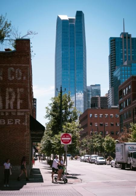 In der Innenstadt von Oklahoma City ragt ein gläserner Wolkenkratzer über Brick-Buildings, Verkehr und Fußgänger.