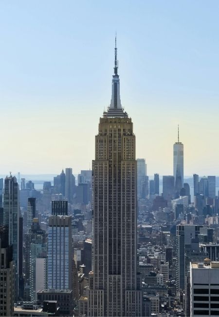 Das Empire State Building ragt über die Skyline von Manhattan, während One World Trade Center im Hintergrund steht.