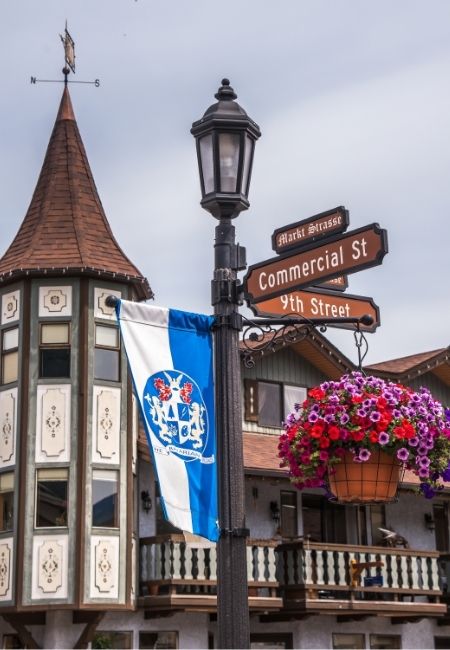 In Leavenworth stehen ein Straßenschild an der Commercial St und 9th Street sowie ein Haus mit Blumenampel.
