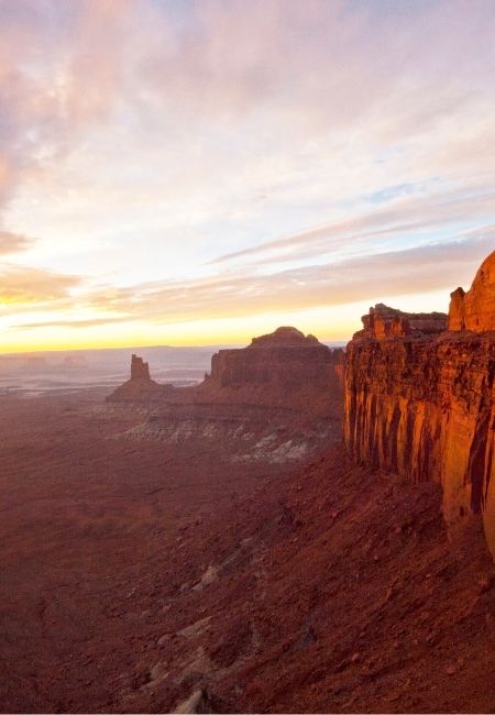 Weite Felslandschaft im Canyonlands National Park mit roten Klippen, Tafelbergen und Abendlicht.