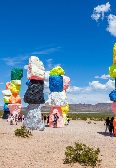 Bunte, übereinander gestapelte Steinskulpturen der Seven Magic Mountains stehen vor dem blauen Himmel südlich von Las Vegas.