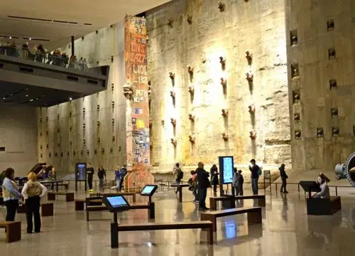 Besucher betrachten Exponate und Informationstafeln im eindrucksvollen Innenraum des 9/11 Museums am Ground Zero.