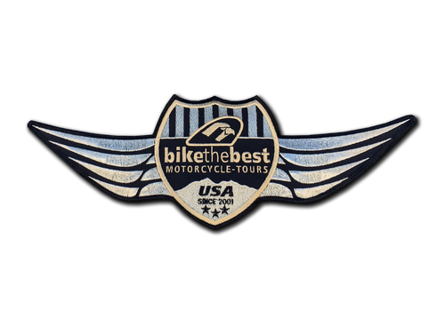 Ein geflügeltes BikeTheBest-Wappen mit USA-Schriftzug und „Motorcycle Tours“ auf schwarzem Grund.
