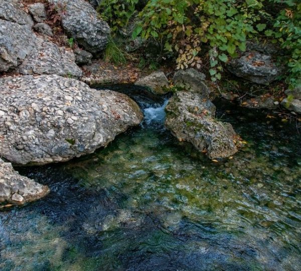 Klares Wasser fließt zwischen hellen Felsen durch die Chickasaw National Recreation Area in Oklahoma an der Route 66.