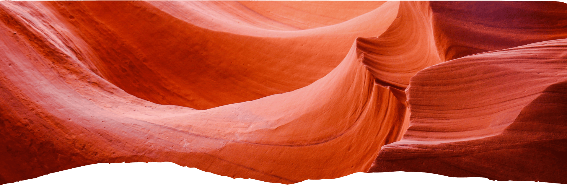 Geschwungene, rot-orange Sandsteinwände formen die engen Felskonturen des Antelope Canyon in Arizona.