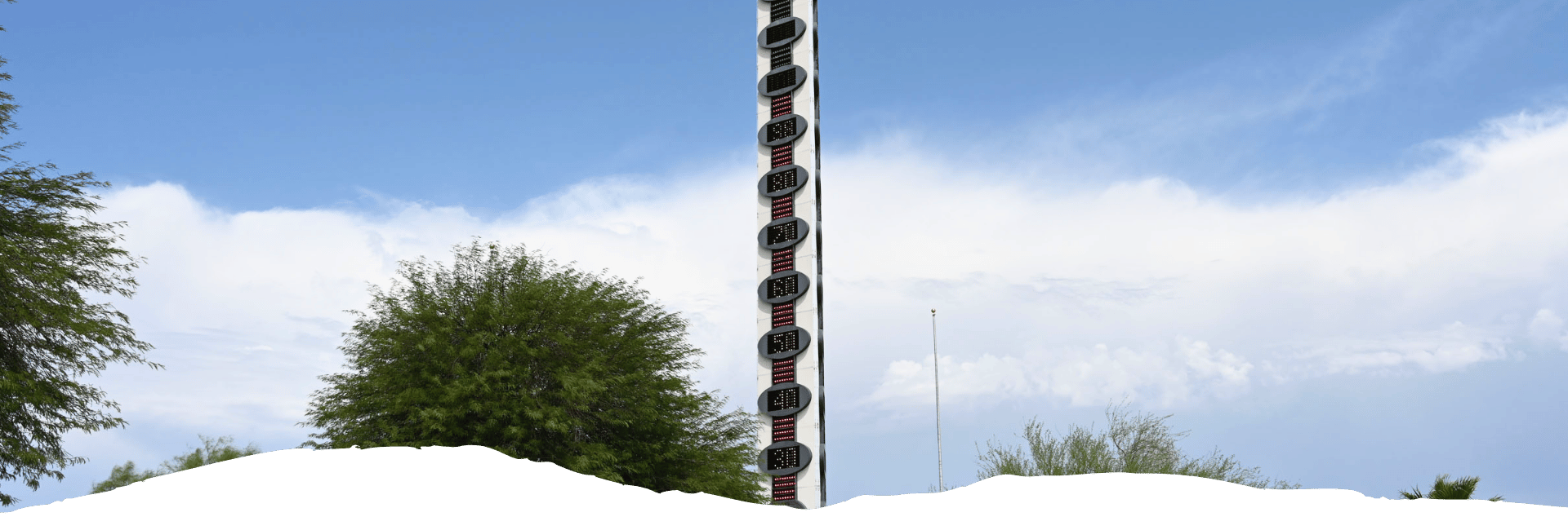 Zwischen Bäumen ragt in Baker, Kalifornien, das höchste Thermometer der Welt mit digitaler Temperaturanzeige in den Himmel.