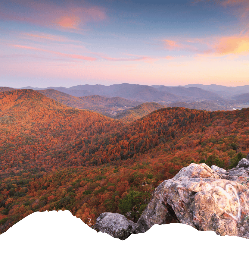 Herbstliche Berglandschaft mit bewaldeten Hügeln und Felsen in den Südstaaten rund um Texas unter rosafarbenem Himmel