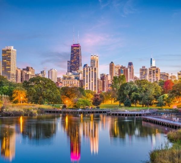 Blick über den See im Lincoln Park auf die beleuchtete Skyline von Chicago mit dem markanten Willis Tower am Abend