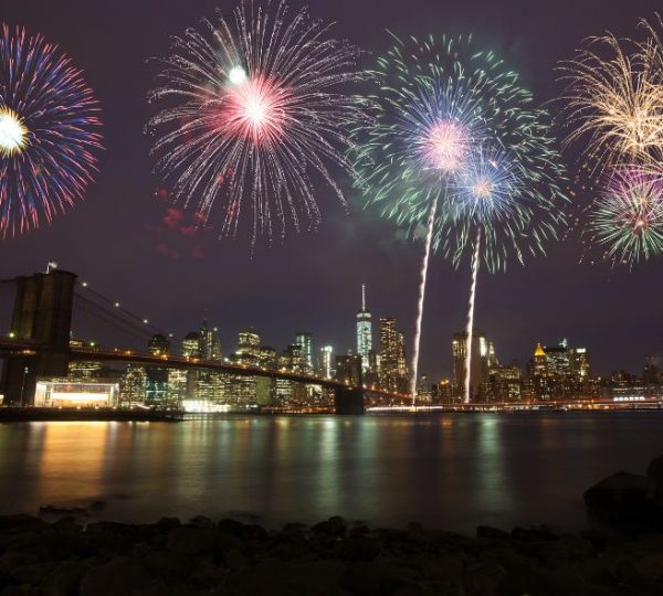 Buntes Feuerwerk erleuchtet die Skyline von Manhattan mit Brooklyn Bridge und One World Trade Center bei Nacht