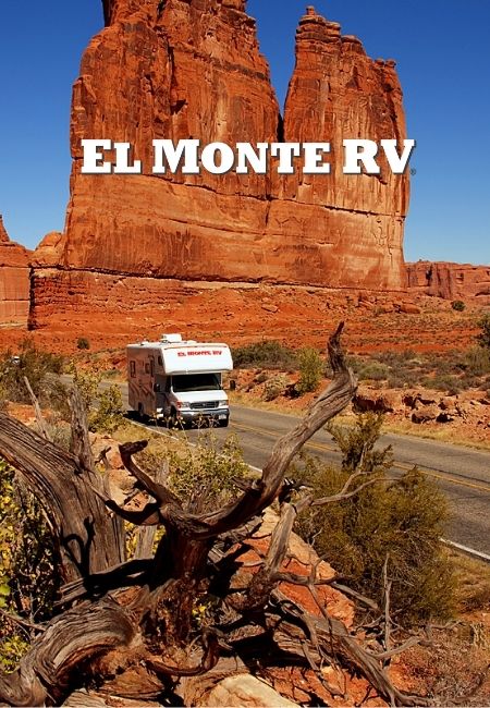 Ein El-Monte-RV-Wohnmobil fährt auf einer Straße durch rotes Felsland unter klarem blauem Himmel.