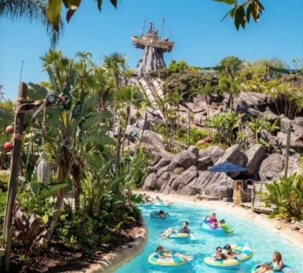 Badegäste treiben auf Reifen durch türkisfarbenes Wasser in der tropischen Wasserparklandschaft von Universal Studios Florida.