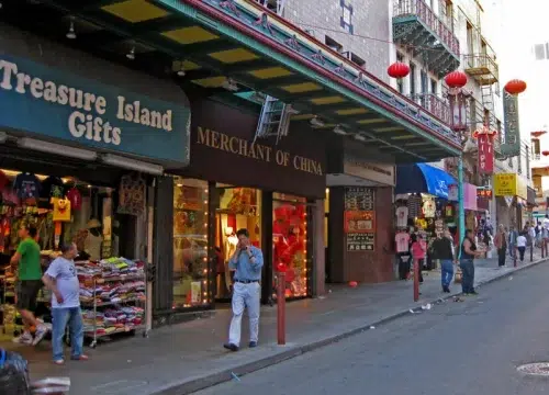 Belebte Straße in San Franciscos Chinatown mit roten Laternen, asiatischen Geschäften und dem Laden Treasure Island Gifts
