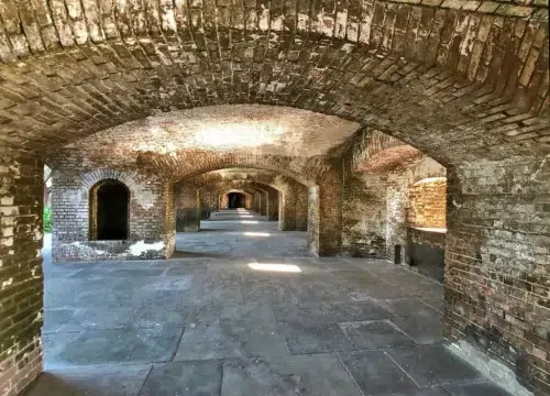 Gewölbegang im historischen Fort Jefferson mit Backsteinbögen, Zellen und Steinboden im Dry Tortugas National Park