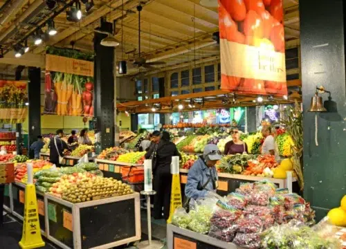 Bunte Obst- und Gemüsestände mit Kundinnen und Kunden im Reading Terminal Market in Philadelphia