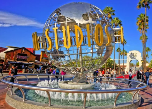 Vor dem Eingang der Universal Studios Hollywood steht ein silberner Globus mit goldenem Schriftzug und einem Brunnen.