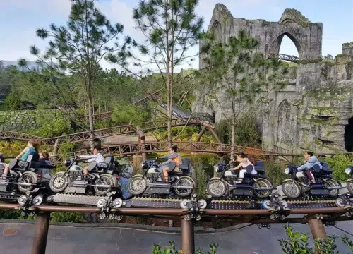 Besucher fahren auf Motorrädern durch eine bewaldete Ruinenlandschaft von Universal’s Islands of Adventure in Orlando