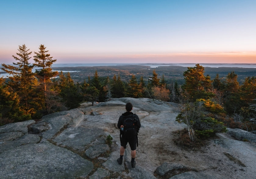 Ein Mann auf einem Gipfel im Acadia Nationalpark im Indian Summer in Neuengland.